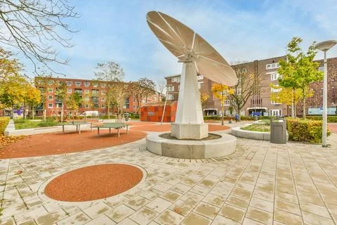 A statue in a park in front of a building Fotos de archivo