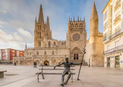 Statue of a pilgrim on a bench, in the square of the Cathedral of Burgos Stock Photos