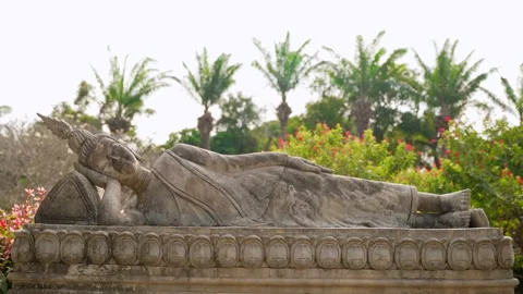 Statue of reclining Buddha with palm trees in the background 스톡 동영상 303684516