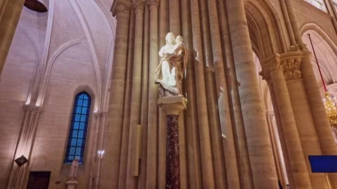 Statue of religious figure on dramatically illuminated column in gothic Notre Stock Footage 302564493