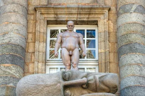 Statue representing a man observing a huge fallen head Stock Photos