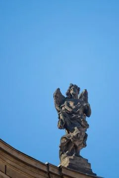 Statue on roof of St. Francis of Assisi church in Prague with blue sky in bac Stock Photos