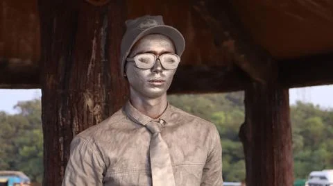 Statue of a silver man. A human model standing for a long time. Stock Photos