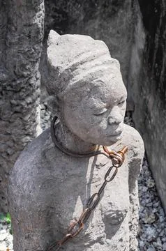Statue slave with rusty chain in former dungeon Zanzibar, Africa Stock-Fotos