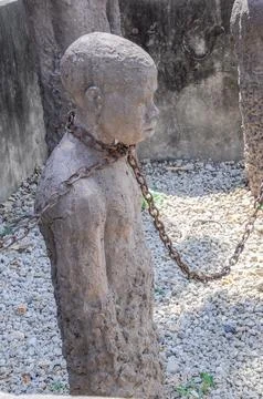 Statue slave with rusty chain in former dungeon Zanzibar, Africa Stock-Fotos