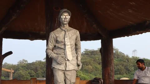 Statue of a standing man. A human model in silver paint. Stock Photos