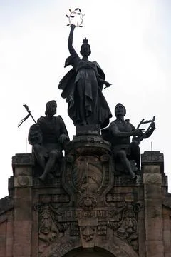 Statue of three figures with their hands extended holding various objects Foto stock