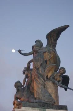 Statue Touching the Moon at Sunset Stock Photos