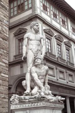 A statue of two persons in front of a building Stock Photos