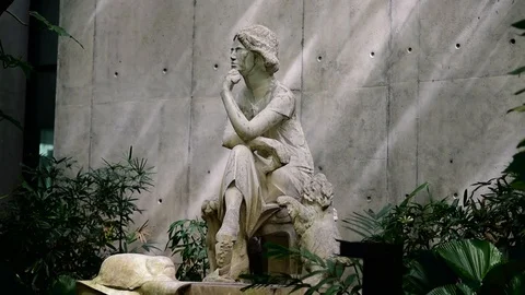 A statue of women sitting between tree. Vídeos de archivo 92771440
