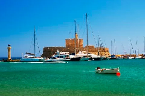 Statues stand either side of Mandraki harbour entrance Stock Photos