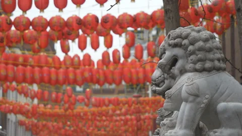 Statues of stone lions with a blurred background of Chinese lanterns. 動画素材 124911940