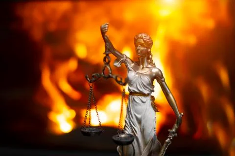 Statuette of Themis on the background of the flame Stock Photos