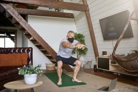 Staying active in self isolation. Middle aged athletic man wearing face Stock Photos