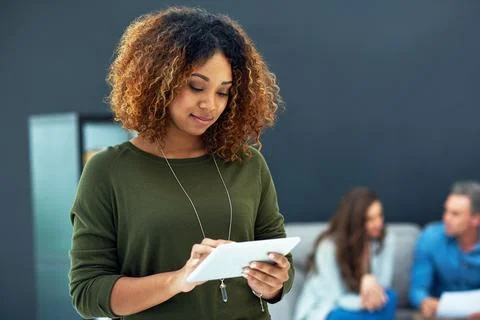 Staying current on industry related developments. a young businesswoman using a Stock Photos