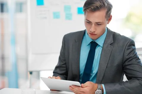 Staying up to date with technology. a handsome young businessman sitting alone Stock Photos