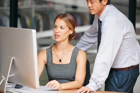 Staying on top of important tasks. two colleagues working together on a computer Foto stock
