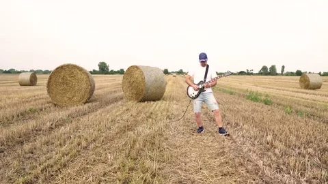 Steadicam camera. A man plays the guitar in the field. Stock Footage 205300349