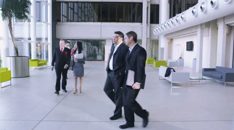 Steadicam dolly back through office following large group of business people.  Stock Footage 32719801