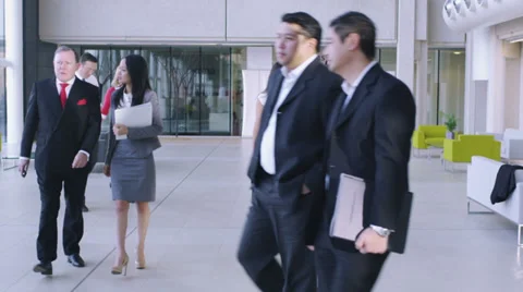 Steadicam dolly back through office following large group of business people.  스톡 동영상 32719802