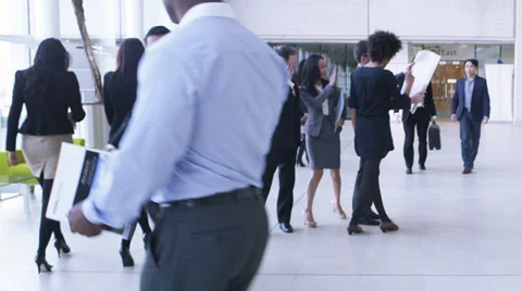 Steadicam dolly back through office following large group of business people.  Stock Footage 32720173