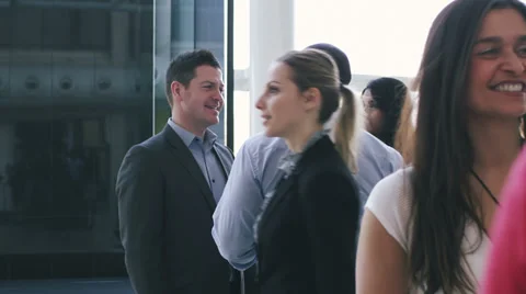 Steadicam dolly back through office following large group of business people.  Vídeo Stock 32720178