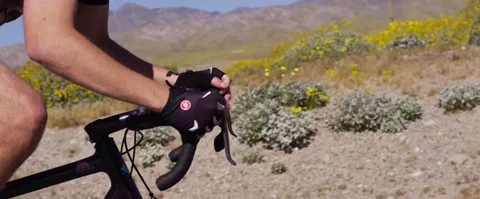 Steadicam medium close up shot of cyclist riding fast on an open road Stock Footage 85065024
