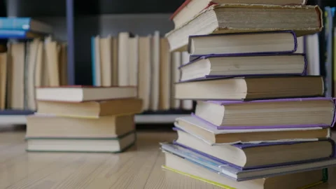 Steadicam shot, 4K. Camera gets closer to the stacked books near a book shelf Stock Footage 155332013