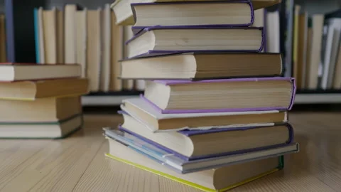 Steadicam shot, 4K. Camera gets closer to the stacked books near a book shelf Stock Footage 157149851