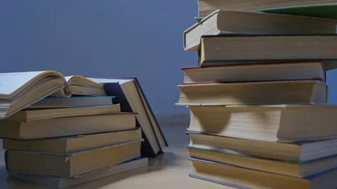 Steadicam shot, 4K. Camera moves around the stacked books on a wooden floor Stock Footage 158089357