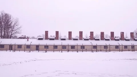 Steadicam shot of concentration camp building in falling snow. 4K clip Stock Footage 72274609