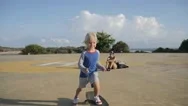 Steadicam Shot Of Cute Child Skateboarding On Helipad In Park And Giving Five Stock Footage