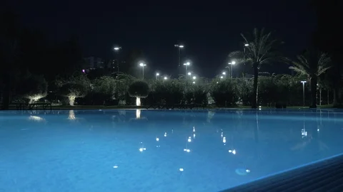 A steadicam shot of a glossy open pool surface in night illumination Stock Footage 99164614