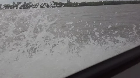 Steadicam shot from left side boat on the river with splashes and distant city Stock Footage 164893152