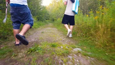 Steadicam shot of two teens walking in the forest Stock Footage 79427583