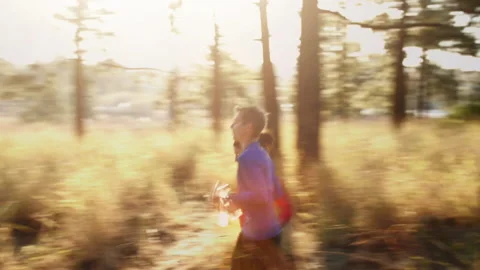 Steadicam shot of young couple running on mountain trail. Stock-Footage 199630541
