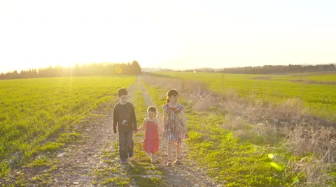 Steady Cam shot of three kids walking on a gravel road during sunset Video stock 59181305