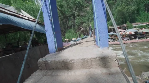 Steady Cam Shot Of Young Men Standing On A Shaky Rope Bridge Stock Footage 100451193