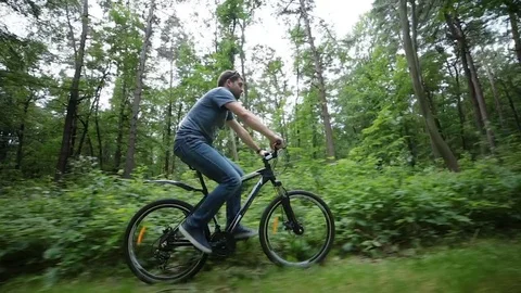 Steady cam view of man riding bicycle on forest road Video stock 77391395