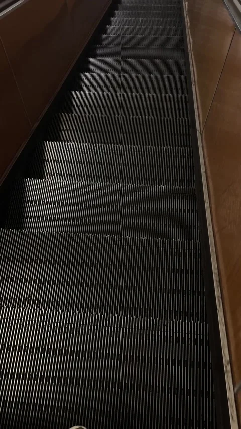 Steady descent of escalator with commuter rhythm inside transit 库存影片 335368691