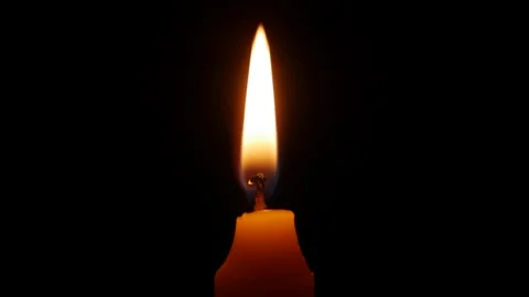 A steady flame trembles softly in broad darkness where each slight movement Video stock 324625086