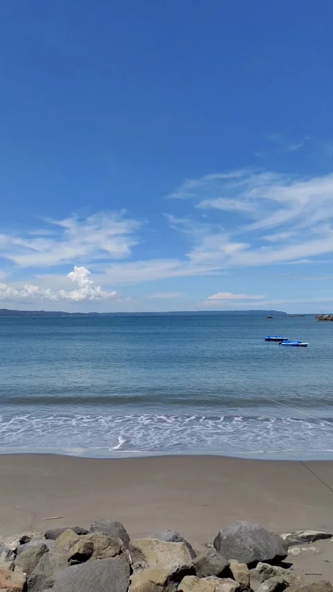 Steady Handheld Tranquil Beach with Distant Boats Clear Blue Sky sandy beach Stockbeeldmateriaal 274304365