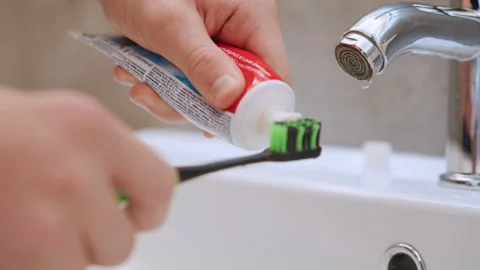 Steady hands applying paste to green bristles carefully. Closeup of hands 库存影片 334785972