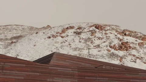 Steady Left to Right Pan of Snowy Hills Above Modern Roofline 動画素材 331221673