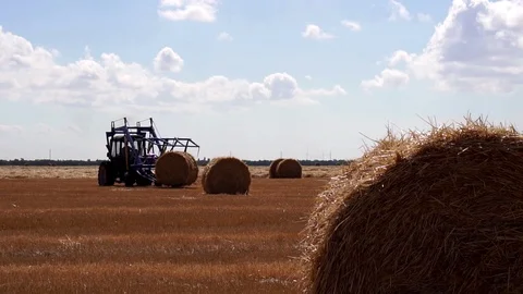 Steady low angle view on modern agriculture tractor vehicle moving heavy bales Stock Footage 94030725