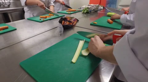Steady moving shot of student's hands in culinary school - cutting vegetables Stock Footage 64866788