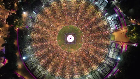 A steady overhead view shows a brightly lit canopy surrounded by dense Garba Stock Footage 347567342