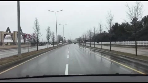 A steady POV shot through the windshield of a car driving on a slick, wet road Stock-Footage 333376635