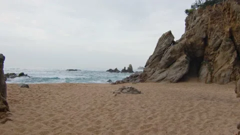 Steady shot between rocks on a wild sea beach in Lloret del mar, in Spain Stock Footage 230097775