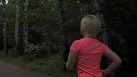Steady shot, camera flying around woman's back while she is running in the park. 스톡 동영상 114714651